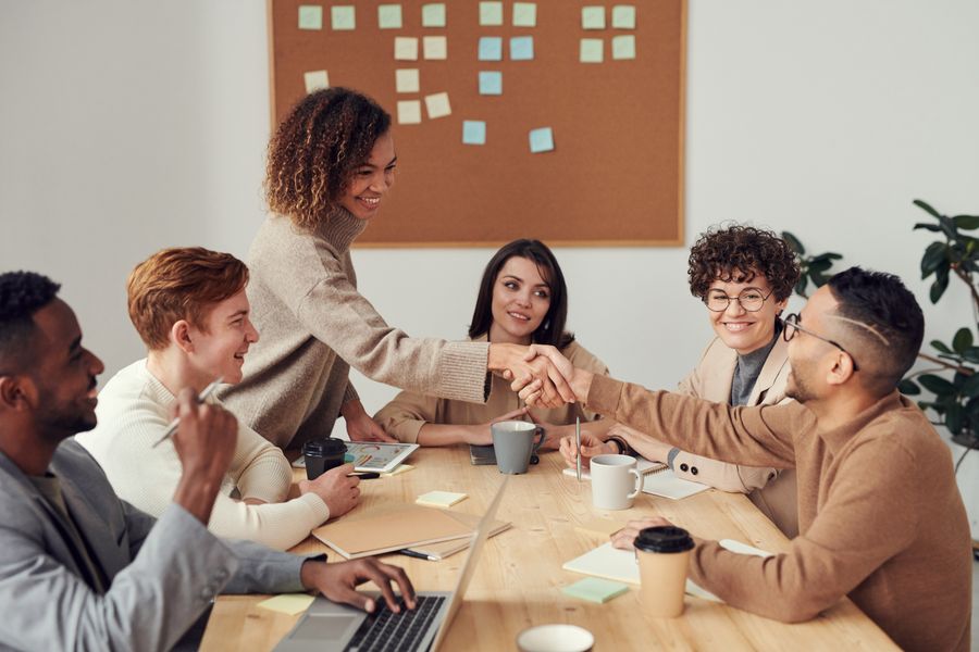 Business team meeting with a handshake across a table